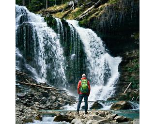 Hiker at Squamish waterfall with lush green backdrop