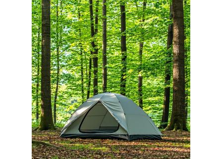 Modern camping tent pitched in a forest clearing.