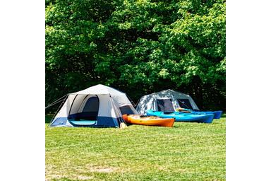 Tents and kayaks available for rent lined up outdoors
